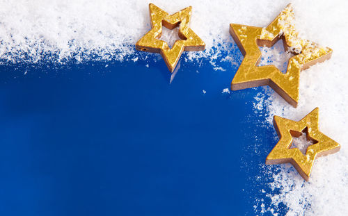 Golden stars on snow against blue background