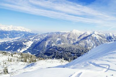 Scenic view of snow covered mountains against blue sky