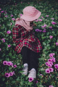 Midsection of woman standing by pink flowering plants