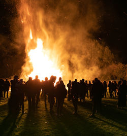 People watching bonfire at night