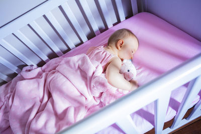 High angle view of baby boy sleeping on bed at home