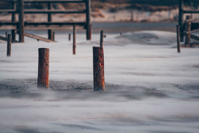 Wooden post on snow covered land