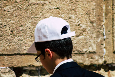 Portrait of man wearing hat against wall