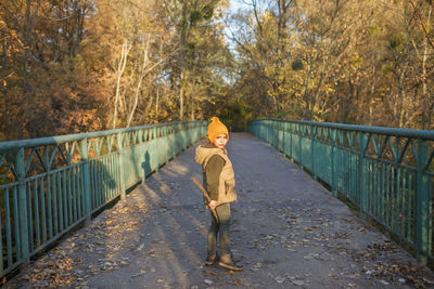 Portrait of woman walking on footbridge
