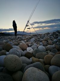 Pebbles on beach against clear sky