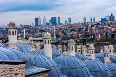 Buildings in city against cloudy sky