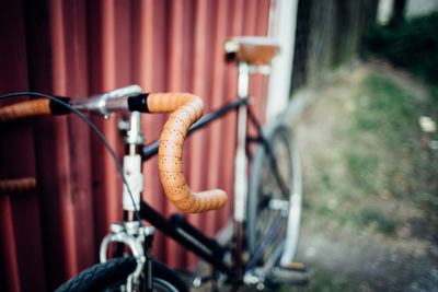 Close-up of bicycle parked against wall