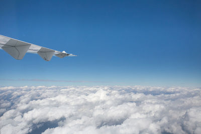 Cropped image of aircraft wing flying in sky