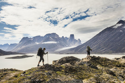 People standing on mountain against sky