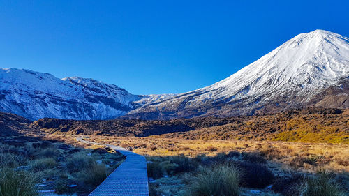 Scenic view of snowcapped mountains against clear blue sky