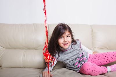 Portrait of smiling girl on sofa at home