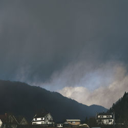 Storm clouds over buildings and mountains