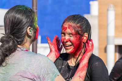 Two young girls playing with colors on the occasion of holi festival