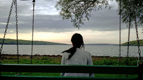 Rear view of woman looking at sea against sky