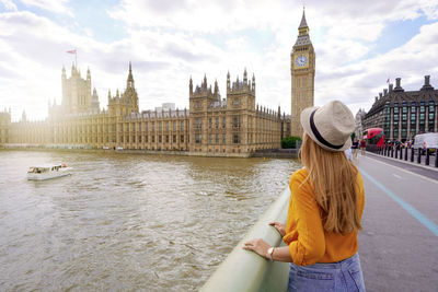 Traveler girl enjoying sight of westminster palace and bridge on thames with big ben tower in london