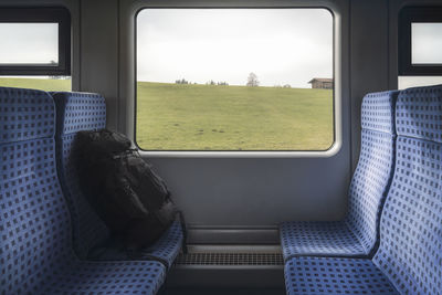 Backpack on train seat by window