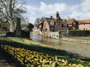 Scenic view of river by buildings against sky