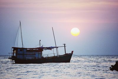 Sailboats in sea against sky during sunset