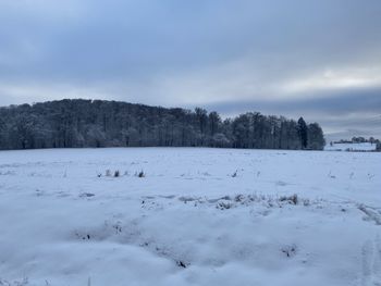 Scenic view of snow covered field against sky