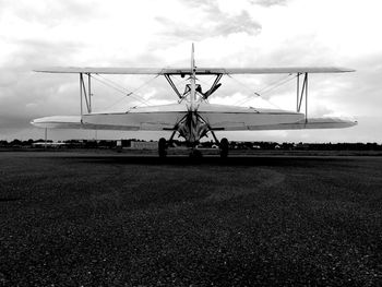 Airplane on runway against sky