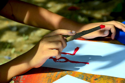 Cropped hand of person painting on paper