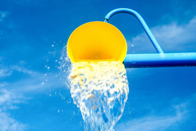 Close-up of yellow water against blue sky