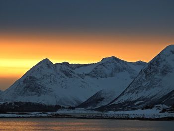 Scenic view of snowcapped mountains against sky during sunset