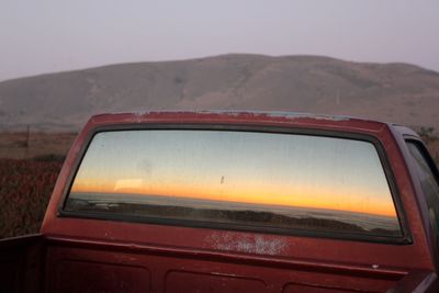 Scenic view of landscape against sky seen through car window