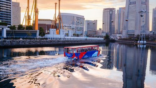 An amphibious bus navigates upstream along the ooka river in the port of yokohama, japan