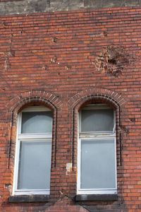 Low angle view of window on brick wall of building