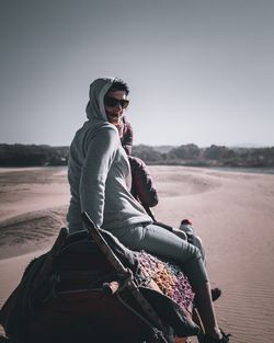 Portrait of mother with daughter riding on camel at desert