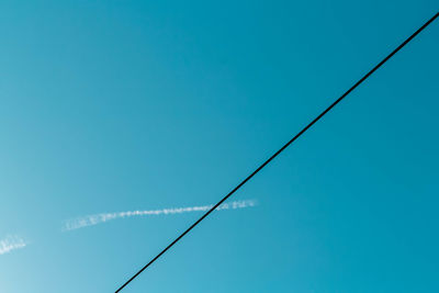 Low angle view of cables against clear blue sky