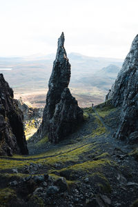 A hiker next to the needle in the quiraing region on the isle of skye.