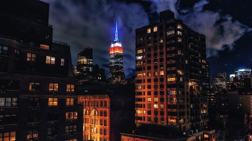 Illuminated buildings in city against sky at night