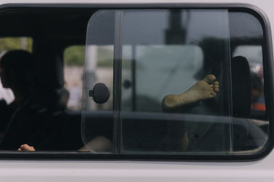 Reflection of man on glass window of train