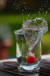 Close-up of water splashing on glass table