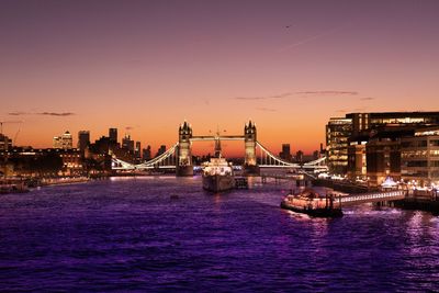 View of illuminated bridge over river against sky during sunset