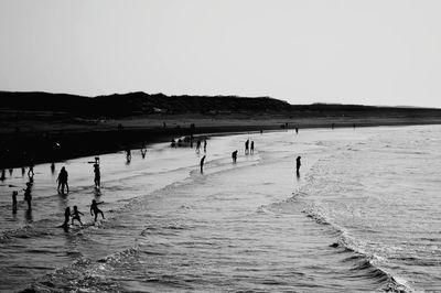 People on beach against sky