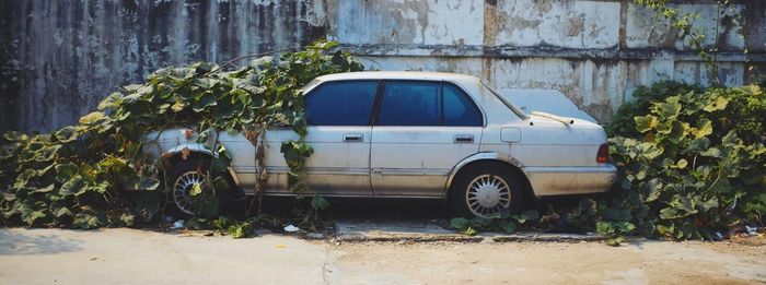 Abandoned car against wall