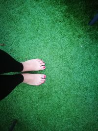 Low section of woman standing on green grass