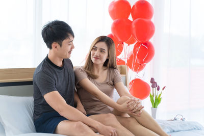 Young couple sitting on balloons