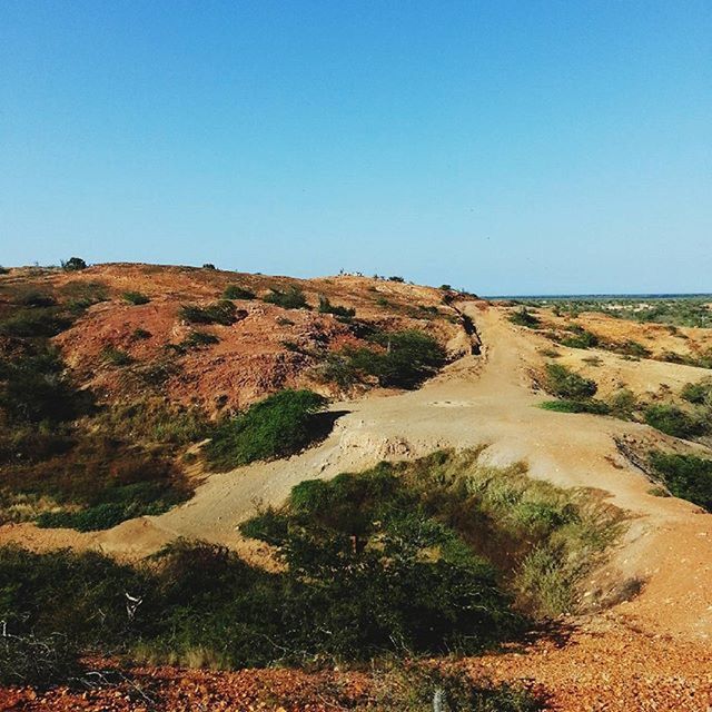 clear sky, copy space, tranquil scene, tranquility, blue, scenics, landscape, beauty in nature, nature, non-urban scene, sea, sunlight, idyllic, sand, mountain, grass, remote, water, horizon over water, day