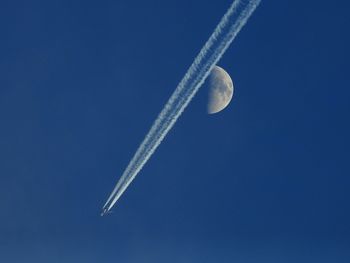 Low angle view of airplane against clear blue sky