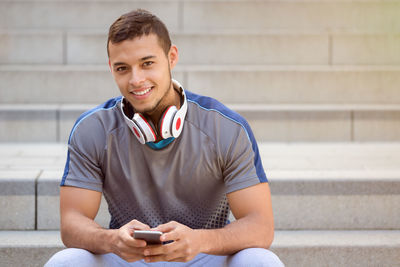 Portrait of smiling young man using mobile phone