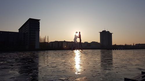 View of city at waterfront during sunset