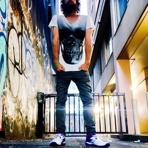 Full length of man standing by railing against building