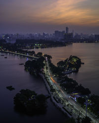 High angle view of city lit up at sunset