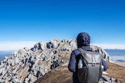 Rear view of man against blue sky