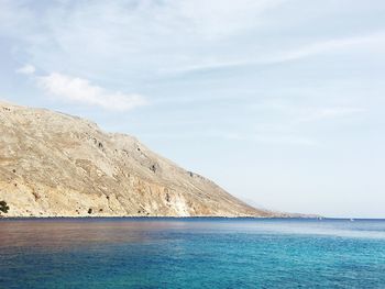 Scenic view of sea and mountain against sky