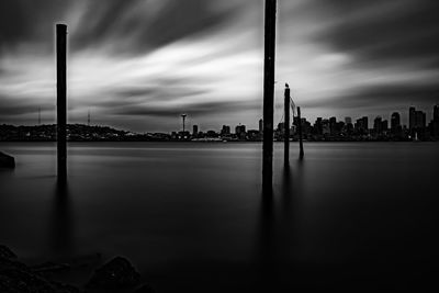 City by sea against sky at dusk